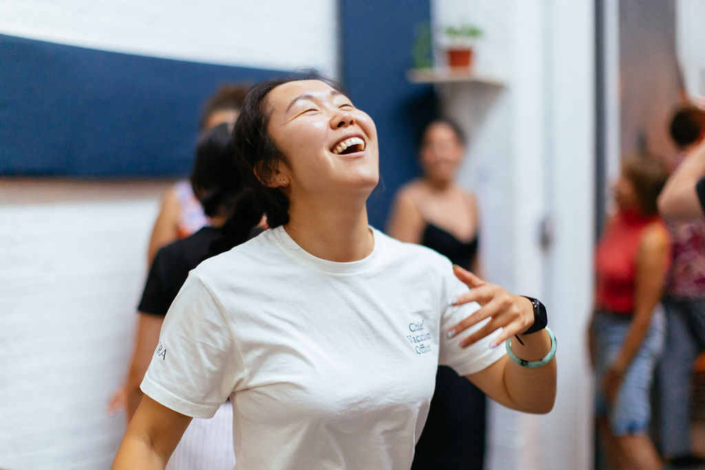 Two people laughing together in a workshop